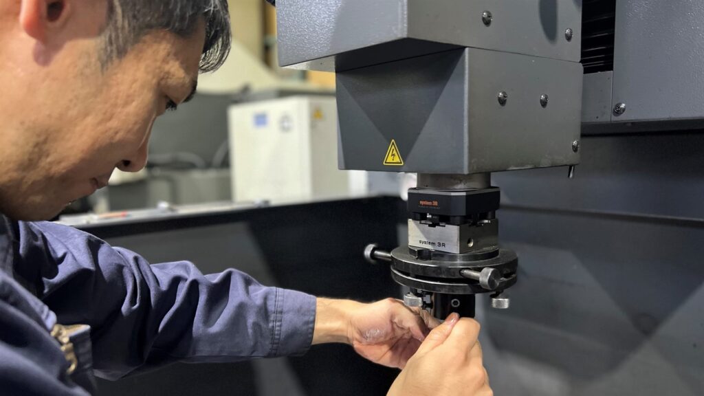 職人がSystem 3R治具に放電加工用の電極を精密にセットしている自社工場の段取り作業